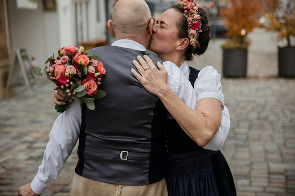 Sabine Beck heiratet im Dirndl und mit Blumen im Haar. Umarmung-Glück-Strahlen
